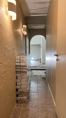 Nymålad korridor med tegelgolv och staplade byggmaterial