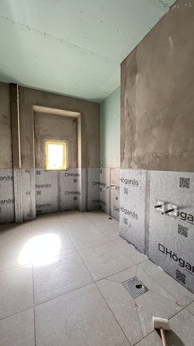 Badrum under renovering med tätskikt, gipsväggar och nygjutna golvytor
