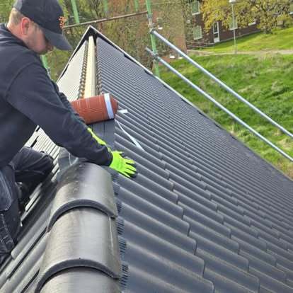  Takläggare från Takgruppen Sverige AB monterar nockpannor på svart tak.