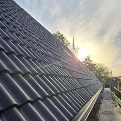 Svart betongtak i motljus – lagt av Takgruppen Sverige AB med fokus på hållbarhet och estetik.