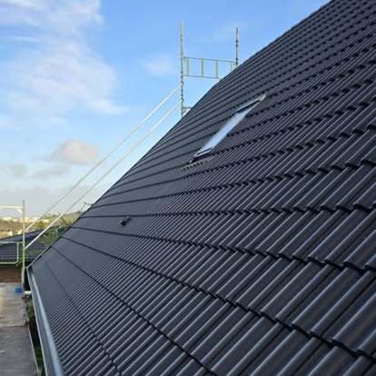 Svart tak i betongpannor med takfönster – nylagt av Takgruppen Sverige AB.