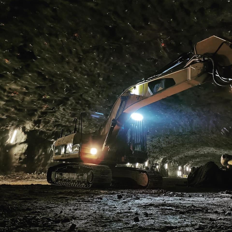 Grävmaskin i arbete under jord – schaktning och tunnelarbete med belysning, avancerad anläggning i Stockholm