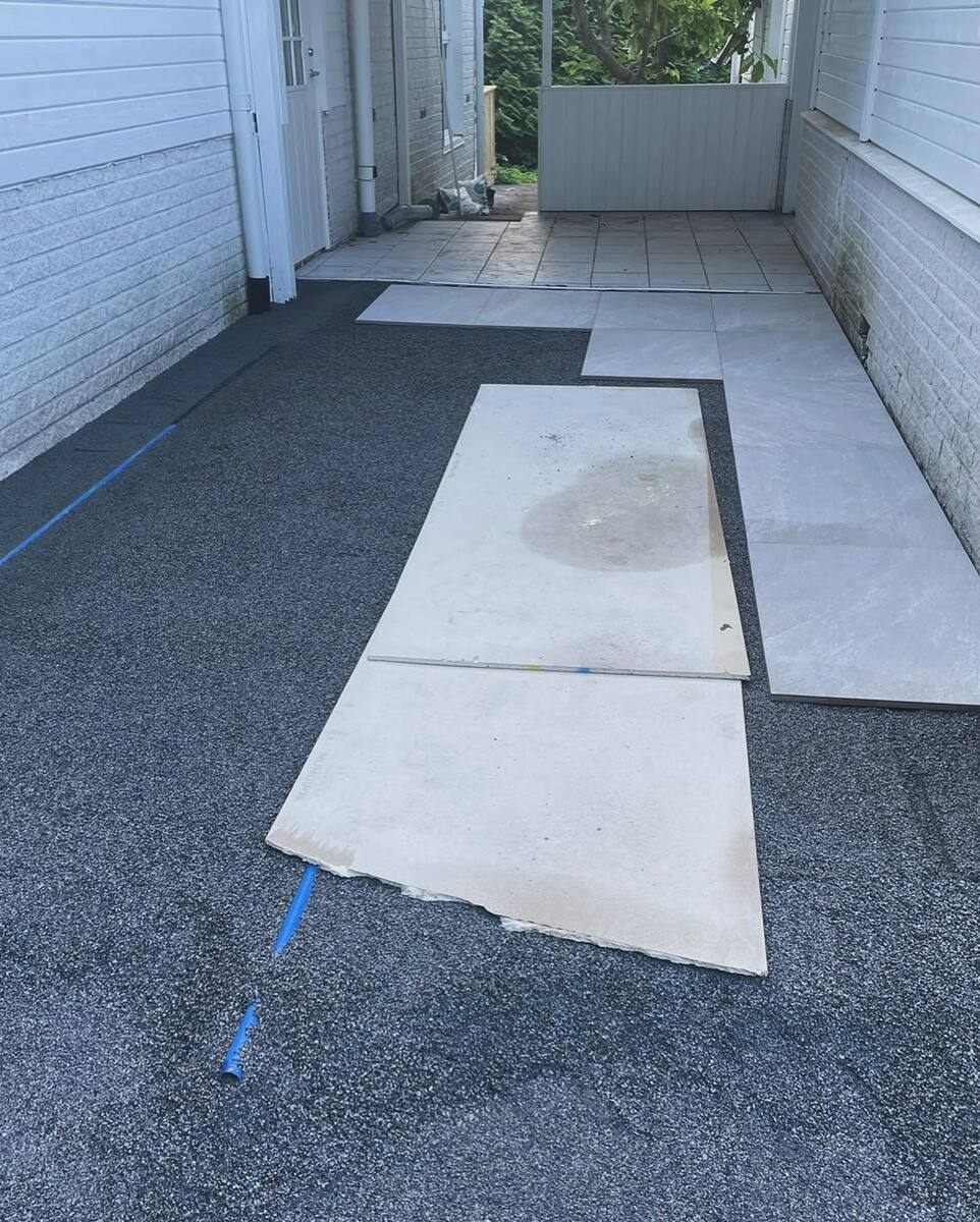 Pågående plattläggning med stenplattor på uppfart – finplanering och entréarbete i Täby