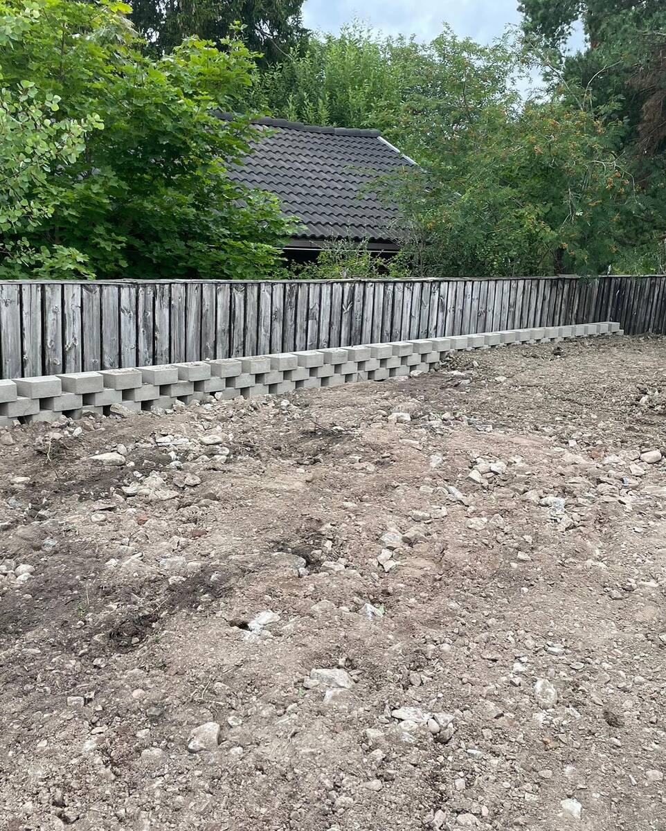 Tomtförberedelse med stödmur i betong – markplanering och dränering i Norrtälje