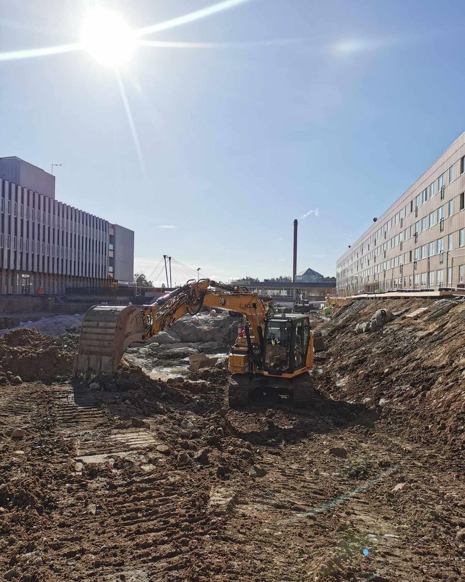 Grävmaskin i arbete med markschaktning på byggarbetsplats – anläggning av husgrund eller infrastruktur