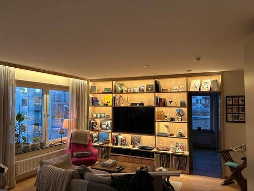 Elinstallation av TV-vägg med LED-belysning och eluttag i vardagsrum i Farsta