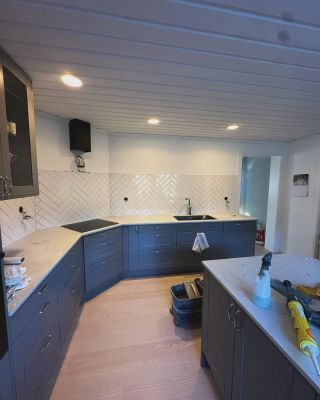 Modern köksrenovering i Borlänge med vitt kakel och integrerad belysning