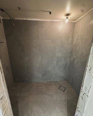 Pågående badrumsrenovering i Borlänge – montering av stora väggplattor