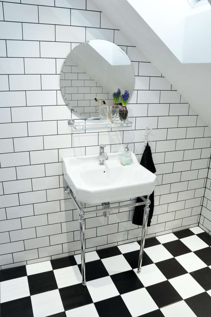 Kompakt badrumsrenovering i Borlänge med schackrutigt klinkergolv och minimalistisk inredning