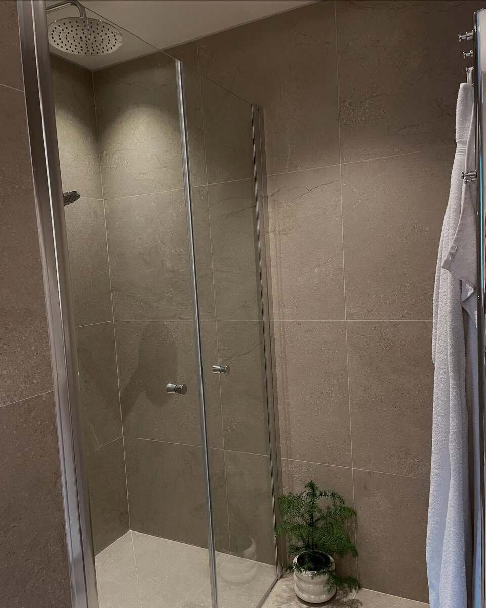 Nyrenoverad dusch med glasvägg i badrum, installerad av LA Rörsystem AB i Sandviken – badrumsrenovering med fokus på design och funktion.
