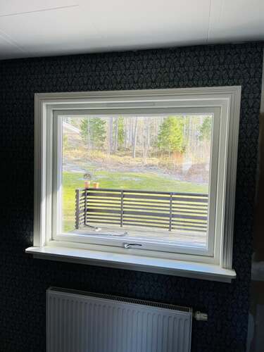 Fönster med vit karm sett från insidan av ett rum