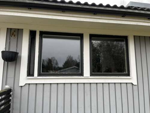 Två fönster monterade i bostadshusets fasad