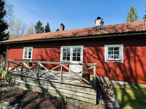 Rött träbyggt bostadshus med fönster och altan