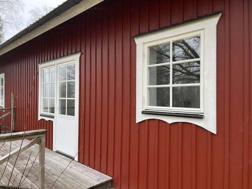 Rött träbyggt bostadshus med fönster