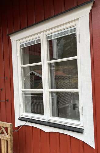 Fönster monterat i röd träfasad på bostadshus