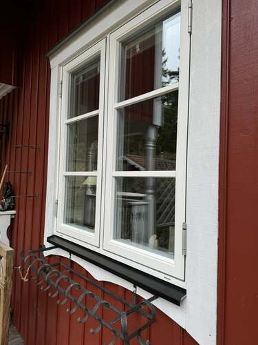 Fönster monterat i röd träfasad på bostadshus