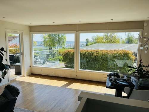 Stort glasparti med fönster sett från insidan av ett rum