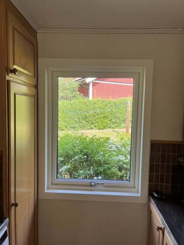 Fönster med vit karm sett från insidan av ett rum