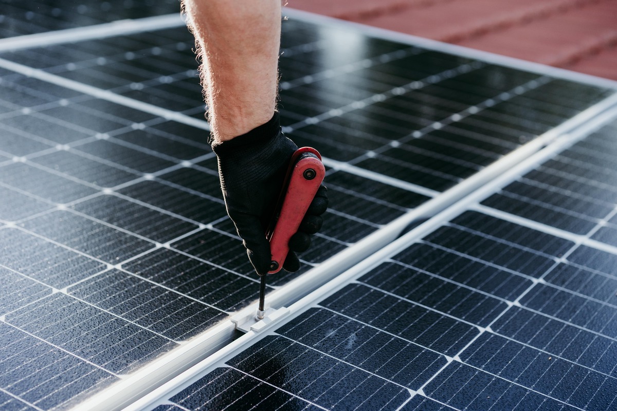 Närbild på montering av solpanel med handverktyg