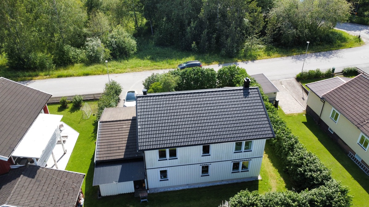 Flygfoto över tvåplanshus med nytt svart tak i takpannemönster