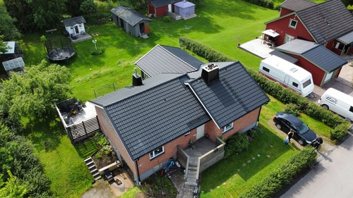 Flygfoto över rad av hus med nytt svart tak i takpannemönster