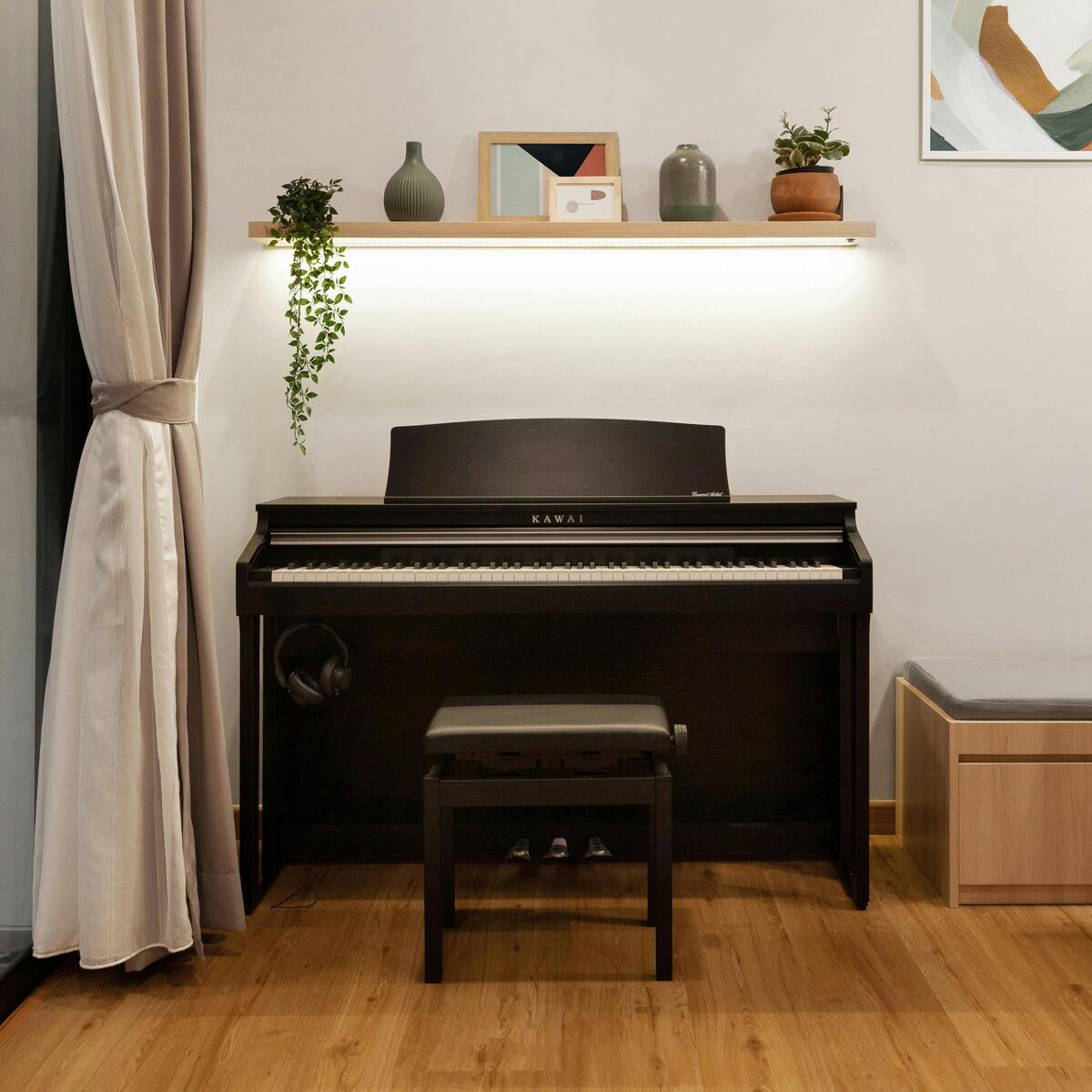 Modernt inrett rum med ett svart digitalpiano och en hylla med dekorationer ovanför.