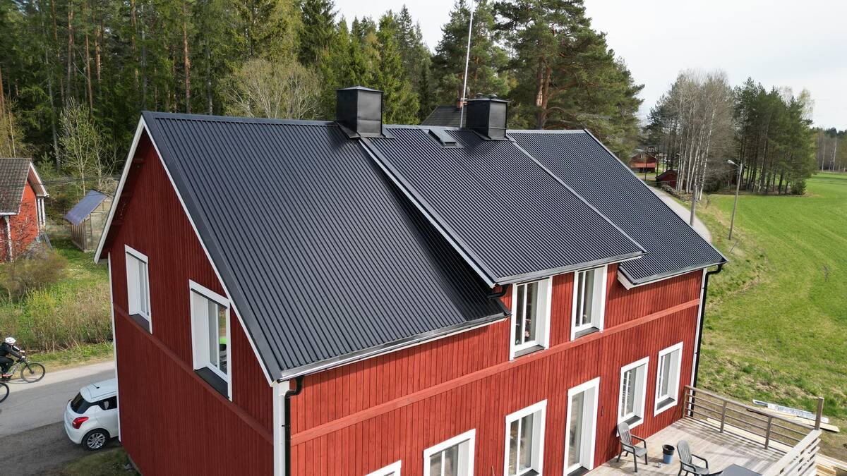 äldre rött hus med svart plåttak
