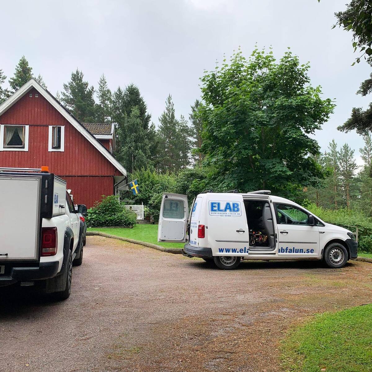 BIld på företagsbil framför rött hus