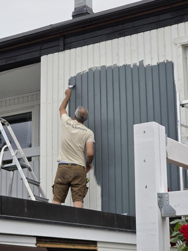 Ghalisson hantverkare målar om fasadpanel på radhus i Stockholm