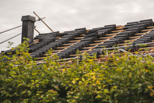 Takläggning i villaområde – takpannor och skorsten synliga