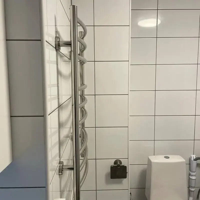 närbild på vitt renoverat badrum med kakel och duschelement