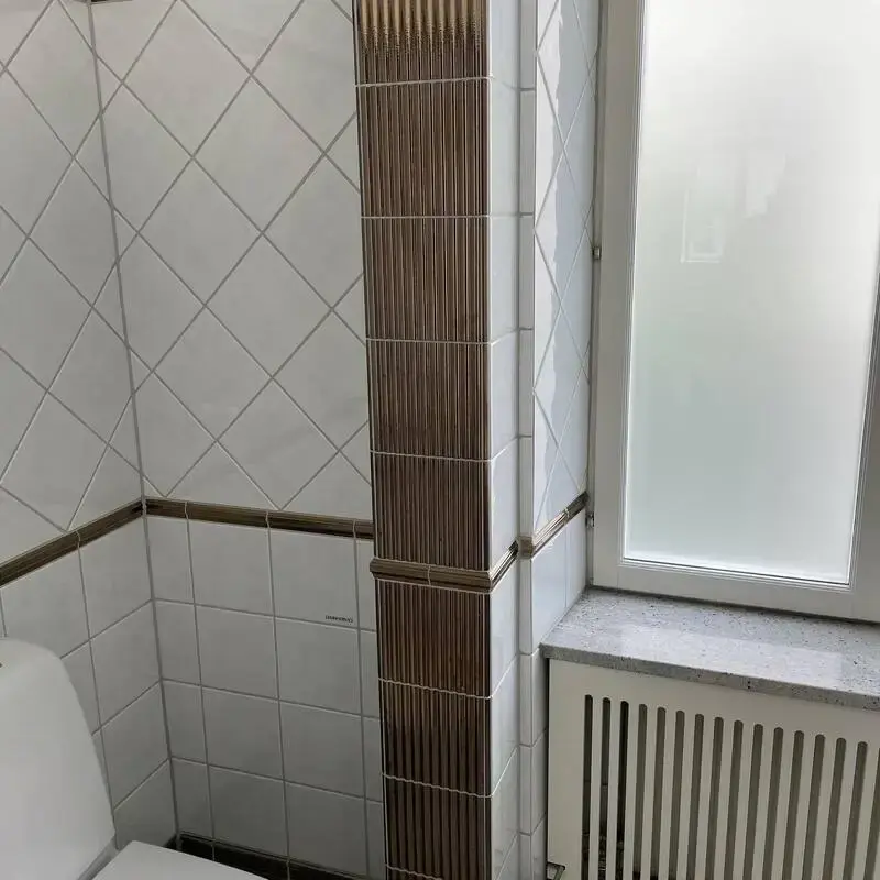 Kaklat badrum med vägghängd toalett, renoverat av DBH Bygg i Stockholm