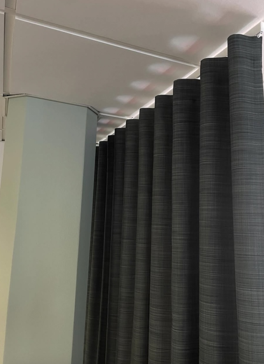 Veckad väggpanel monterad som rumsavskiljare i kontors- eller loungemiljö.