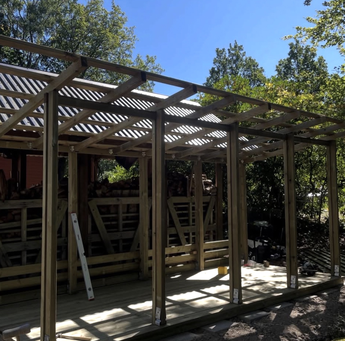 Trästomme till pågående utomhusbyggnation med reglar och takstöd monterade