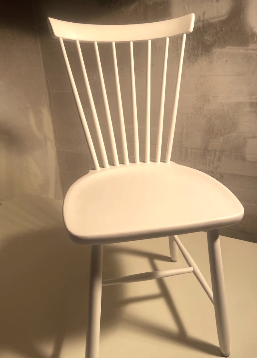 Trästol som renoverats och målats vit vid möbelrestaurering.