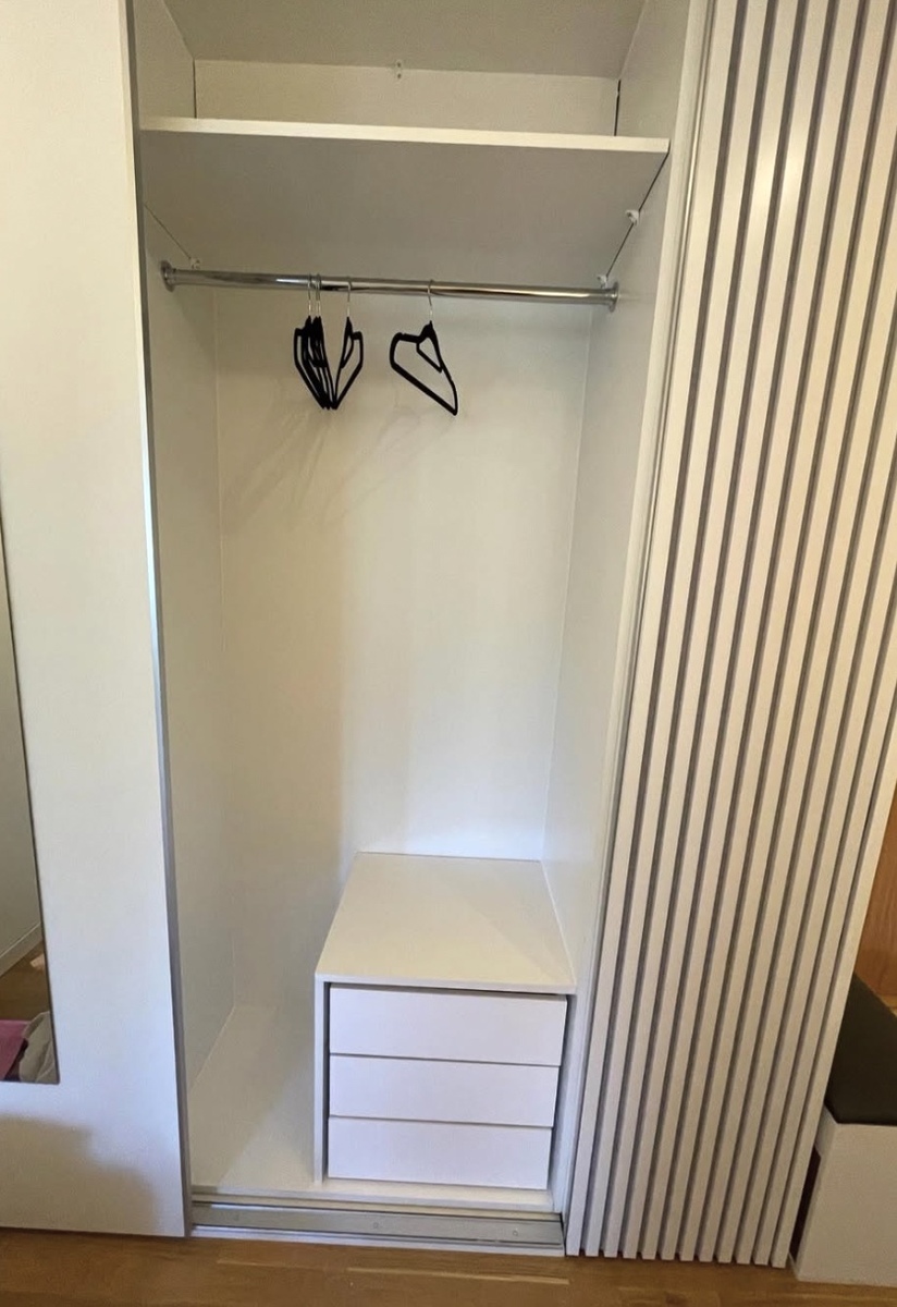 Platsbyggd garderob med sittbänk, lådor och klädstång installerad i hall