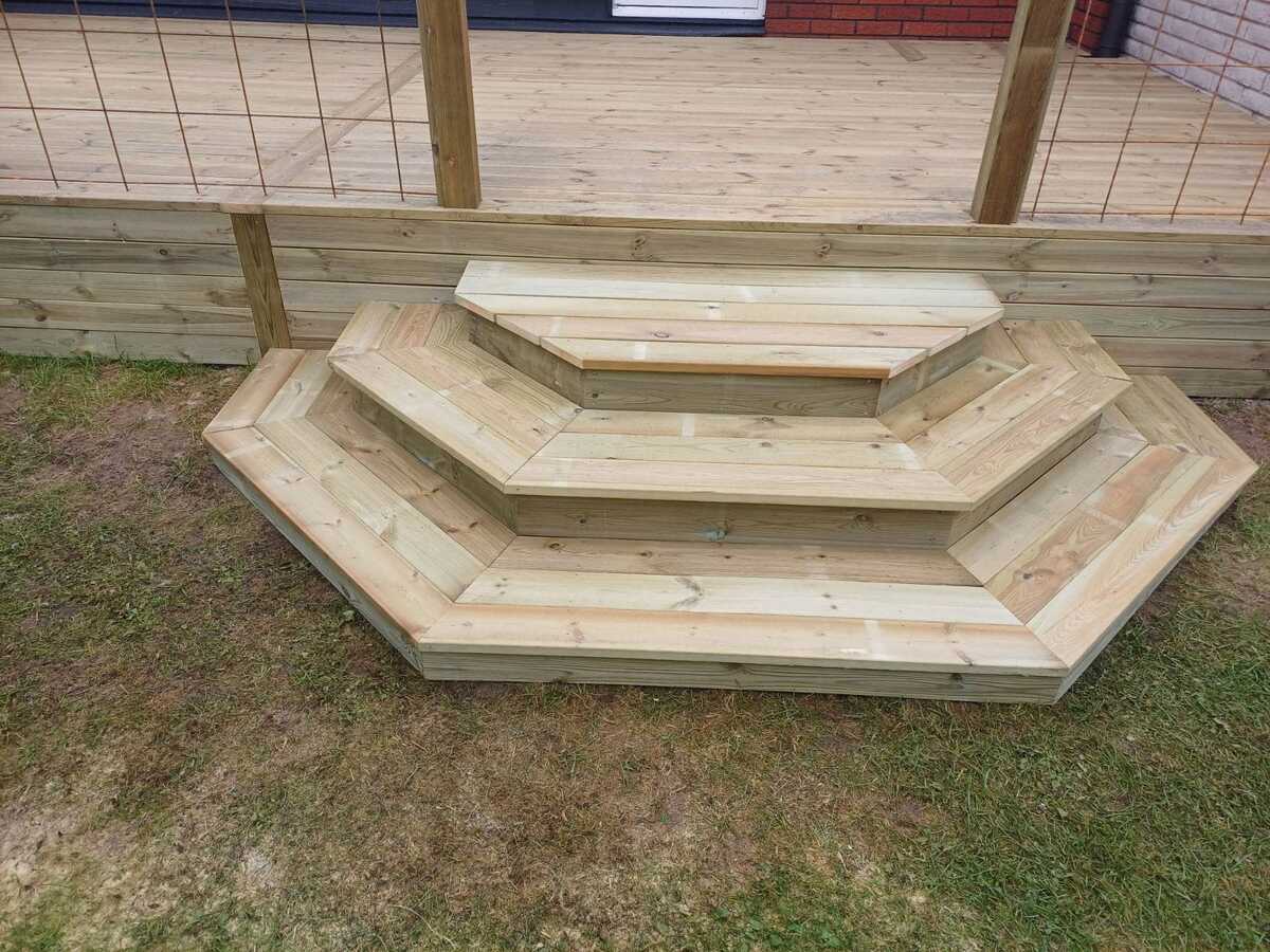 Nybyggda trappsteg i trä där markarbete och nivåanpassning har utförts vid entré till fastighet