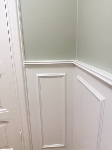 Detaljbild på vit profilerad panelvägg med taklist i hörn