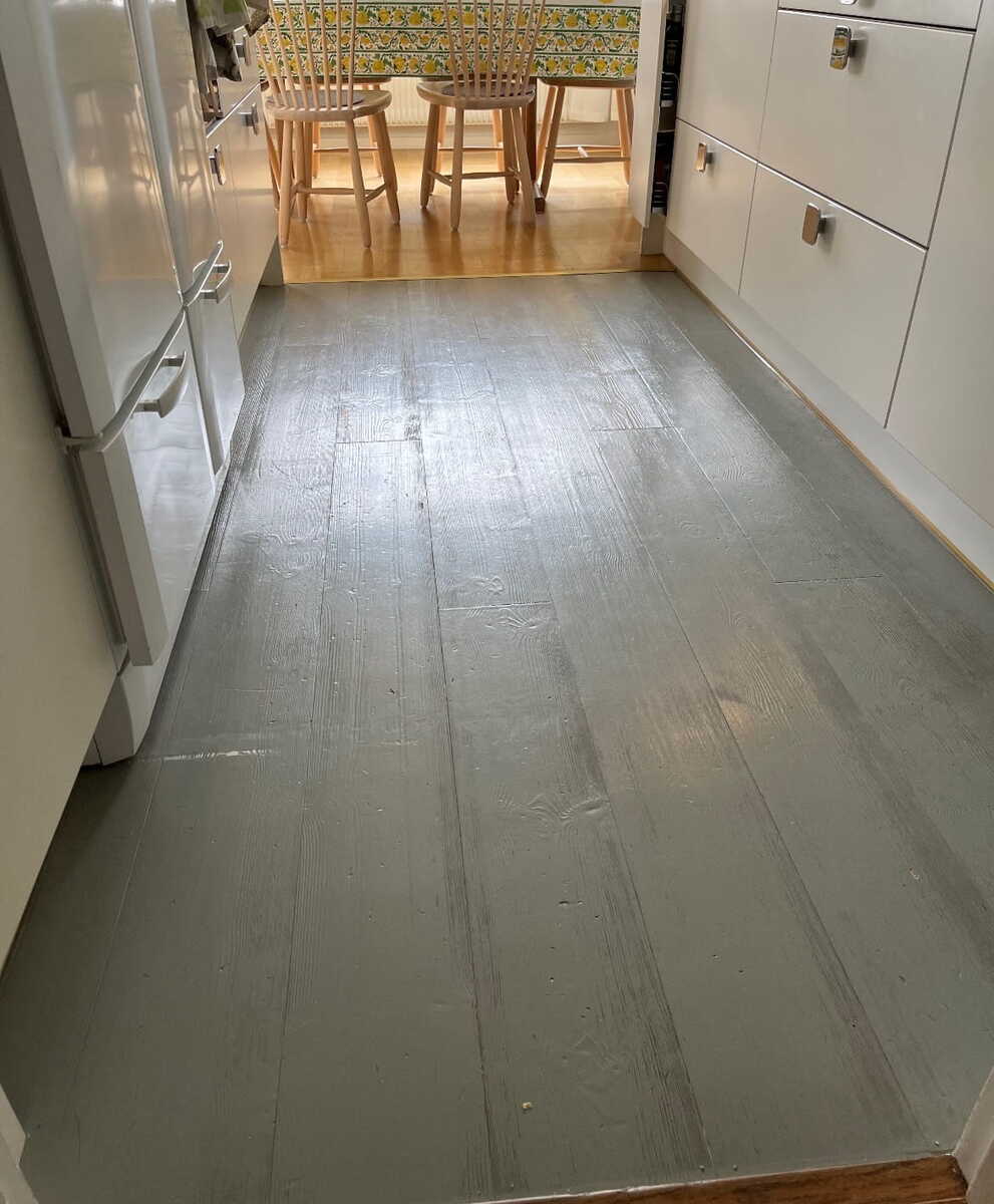 Nymålat och behandlat trägolv i kök efter golvrenovering.