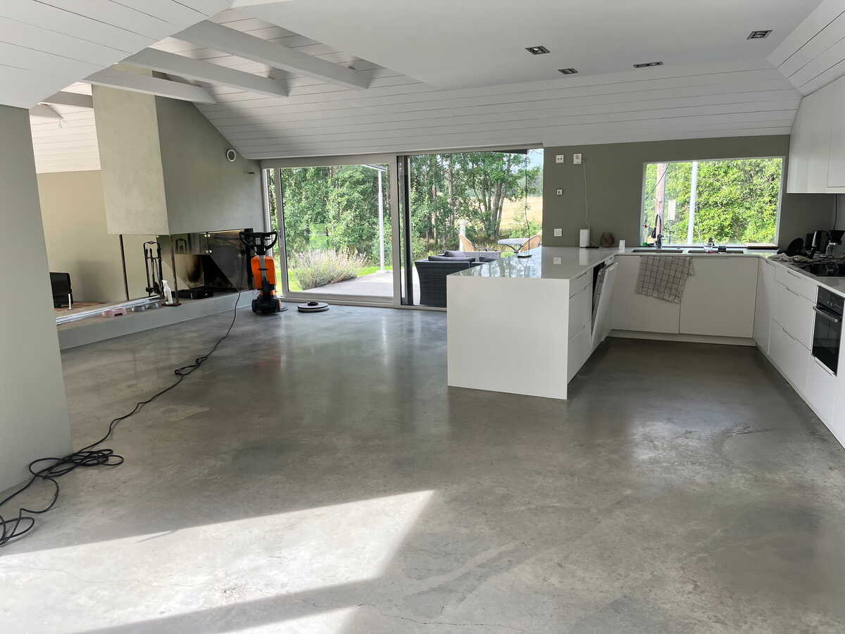 Öppen planlösning med behandlat betonggolv efter golvvård.