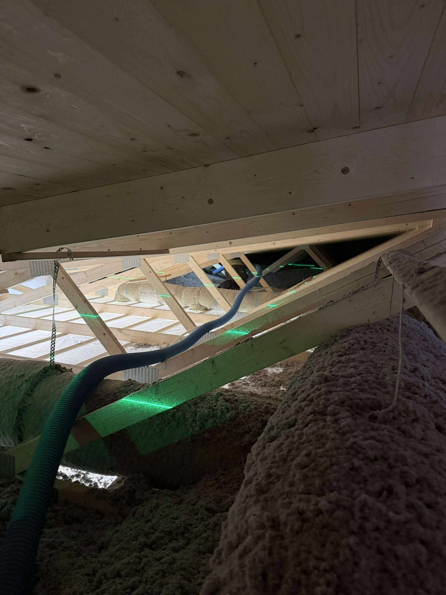 Vind med lösullsisolering och installationsslang i takkonstruktion