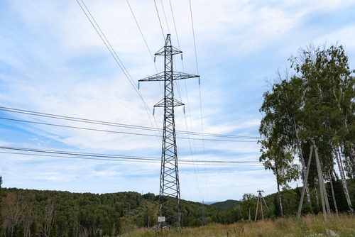 Högspänningsledning och kraftledningsstolpe i landskap
