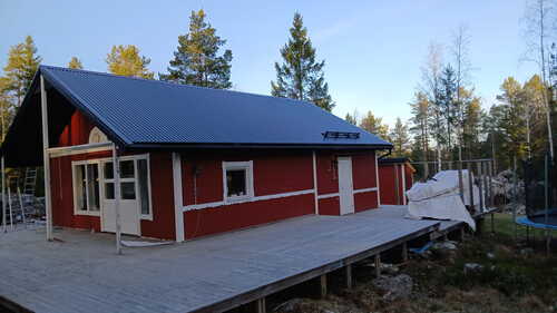 Rött hus med nytt tak och stor altan