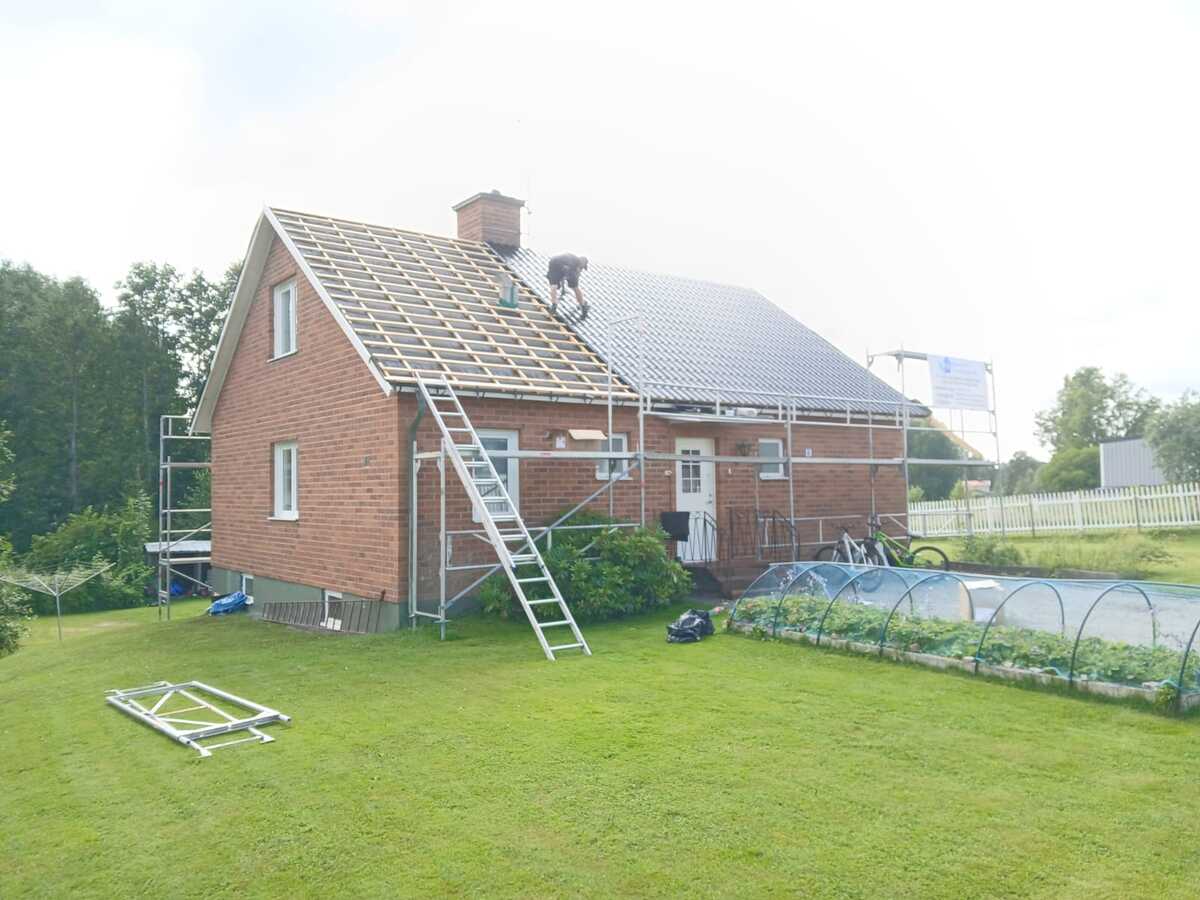 Hus där takarbete pågår med byggställning