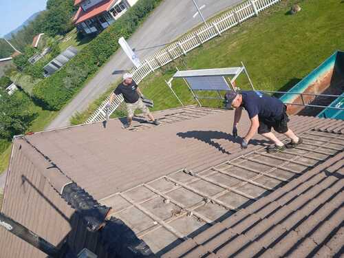 Hantverkare som lägger nytt tak på bostadshus