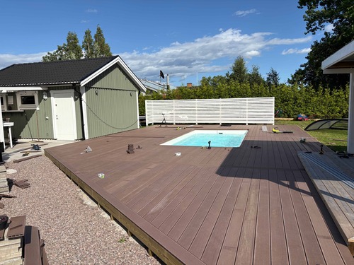 Stort trädäck i komposit runt pool, byggt av BMR Värmland