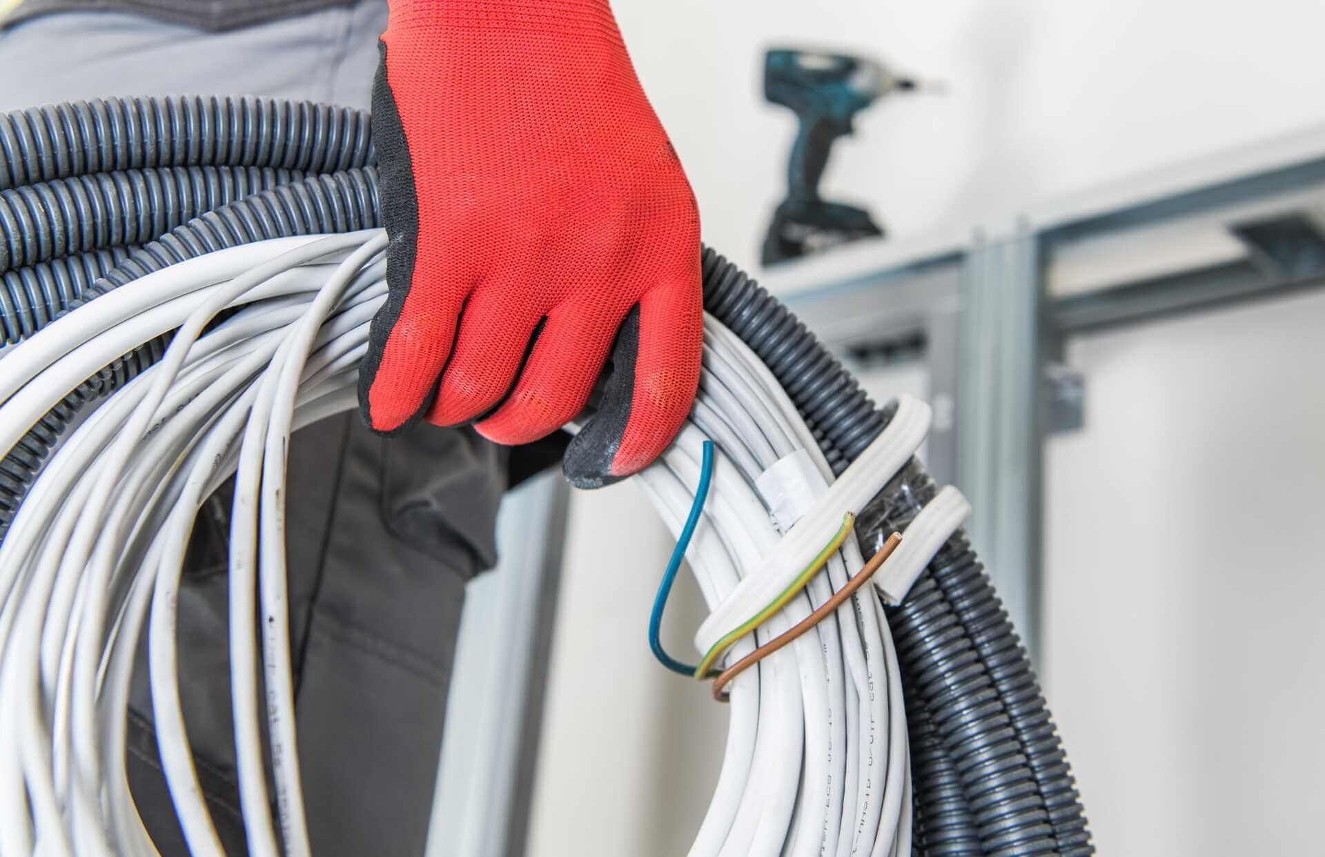 Elektriker håller rulle med elkablar och rör