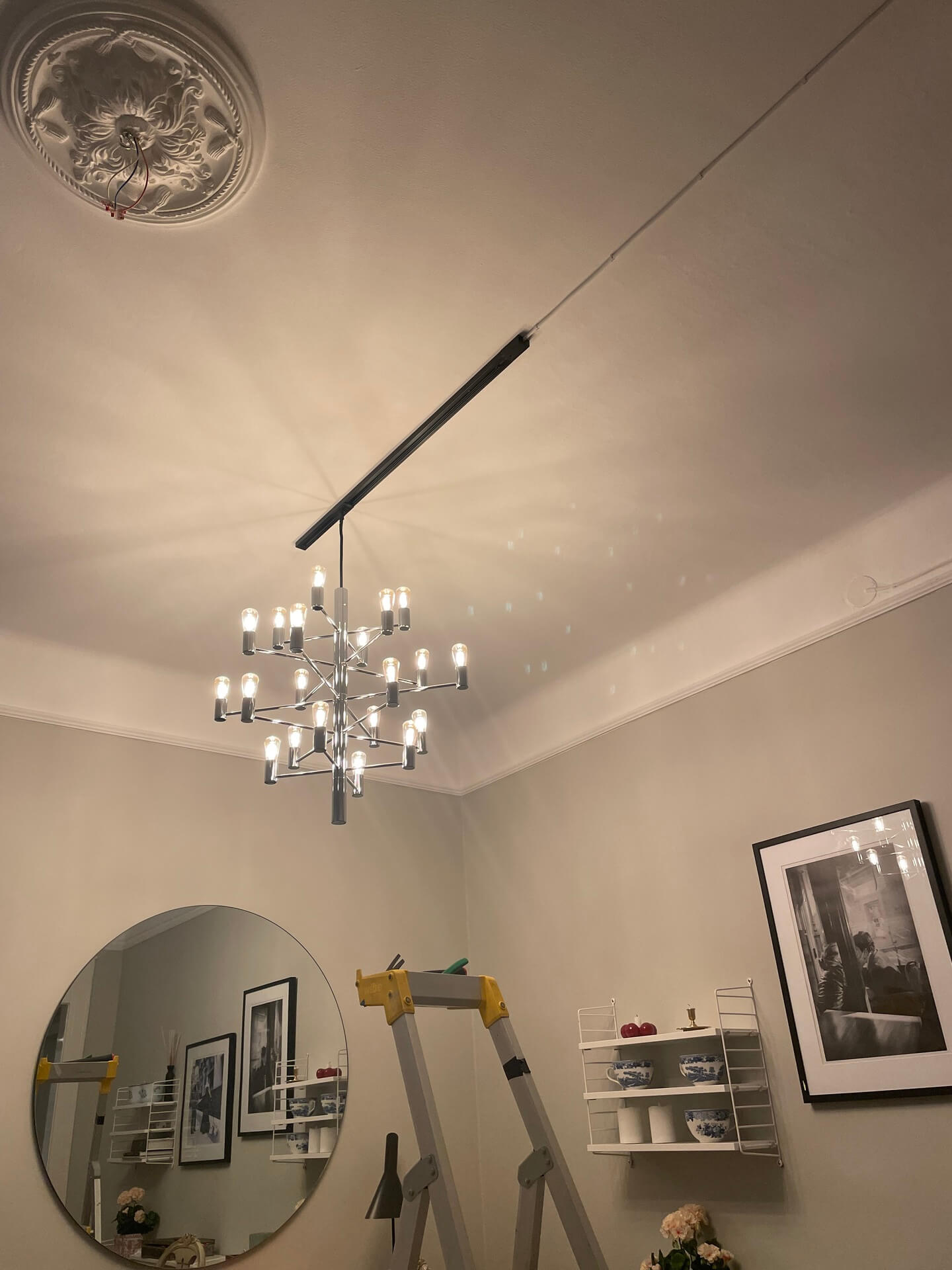 Installerad ljuskrona med skenbelysning i vardagsrum
