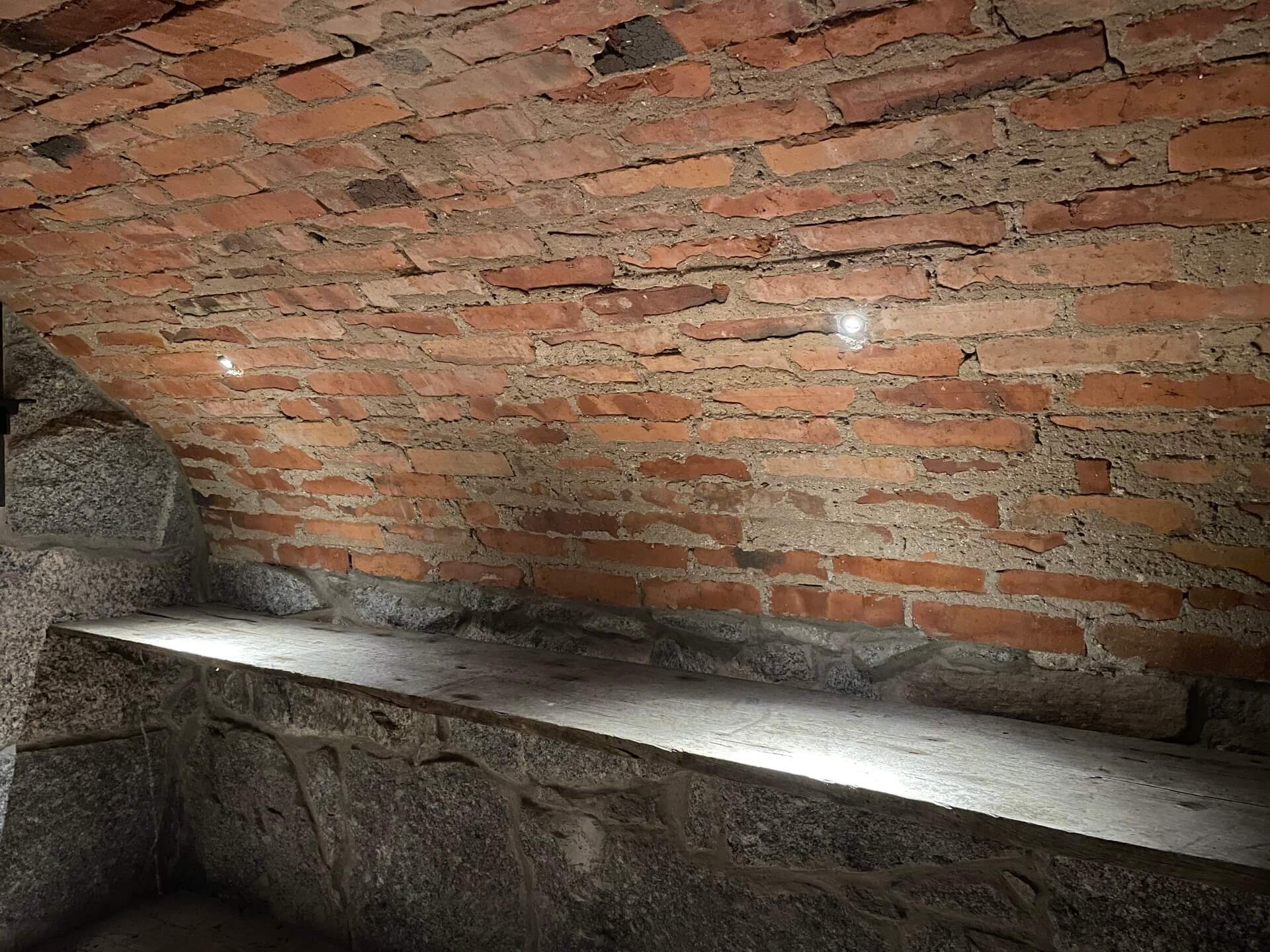 Källarutrymme med tegelvägg efter installation av spotbelysning