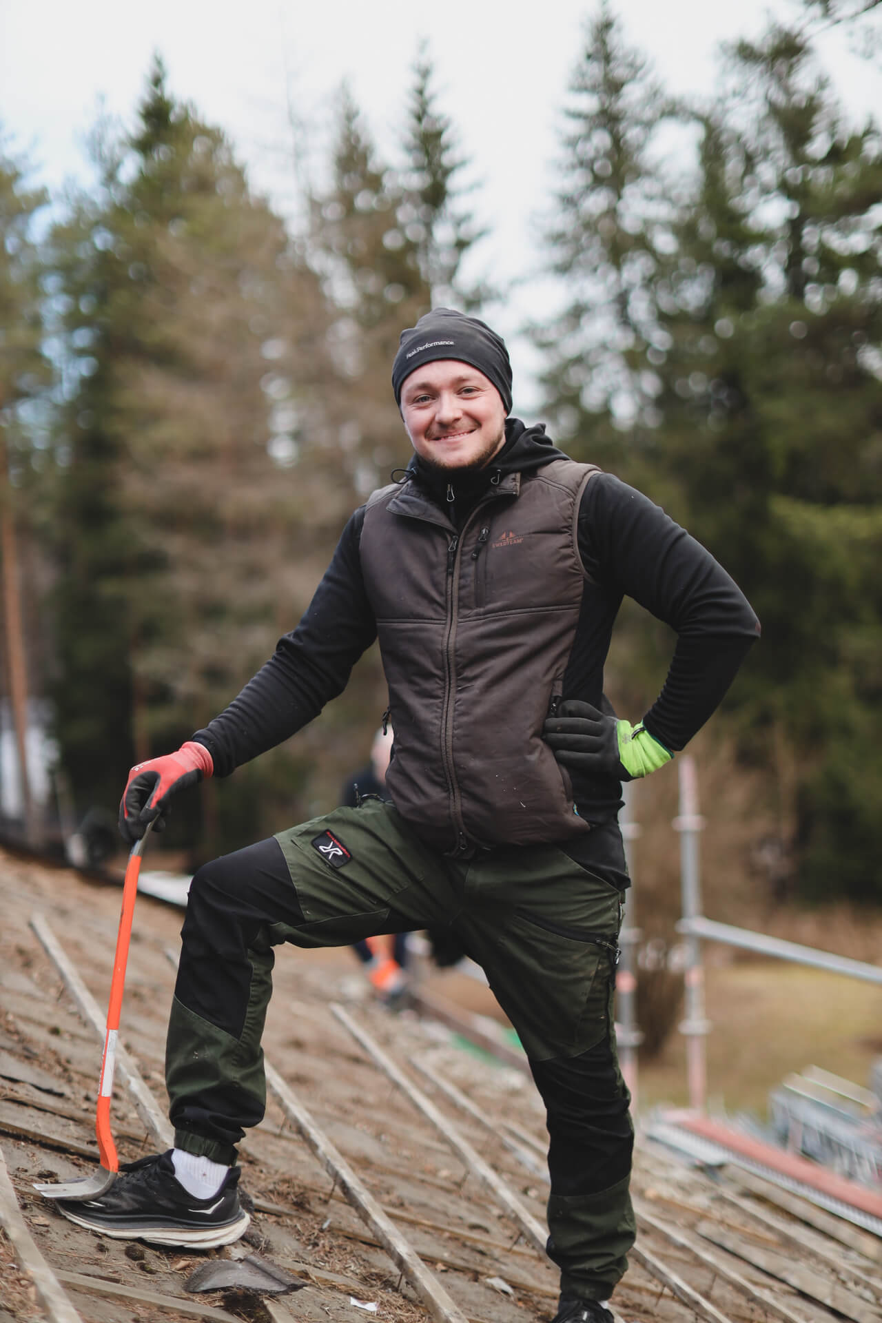 Leende person med arbetsverktyg utomhus